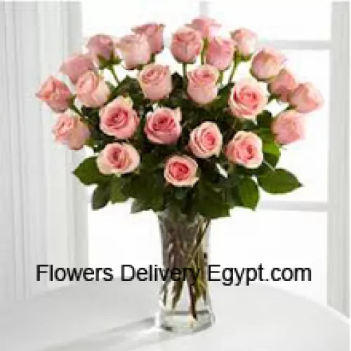 24 roses roses avec quelques fougères dans un vase