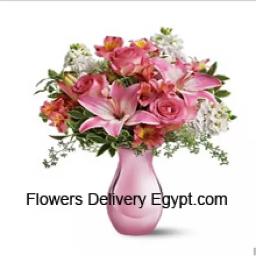 Roses roses, lys roses et diverses fleurs blanches avec quelques fougères dans un vase en verre