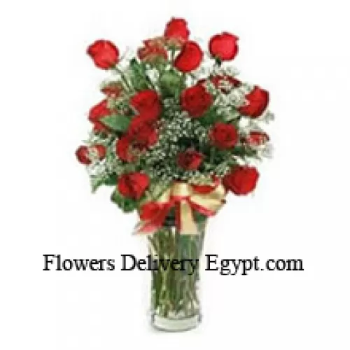 24 Red Roses With Some Seasonal Fillers In A Glass Vase